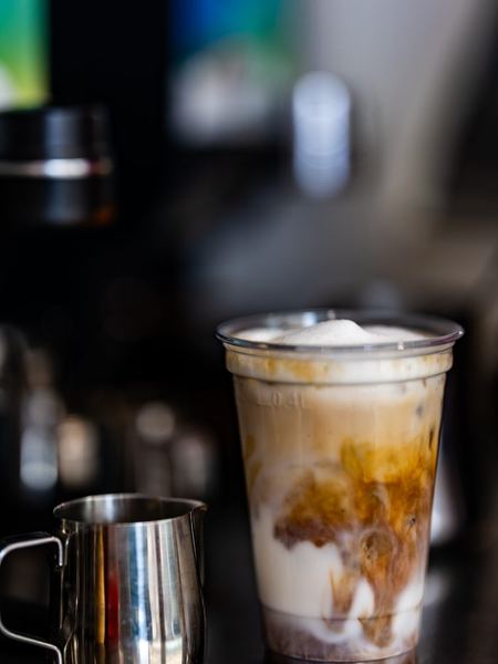 An iced coffee being finished at the bar.