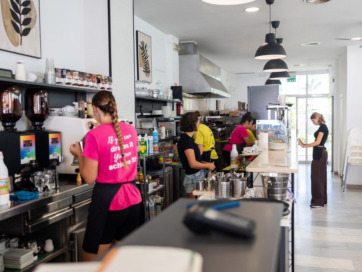A barista steaming milk behind the Café Nomad bar.